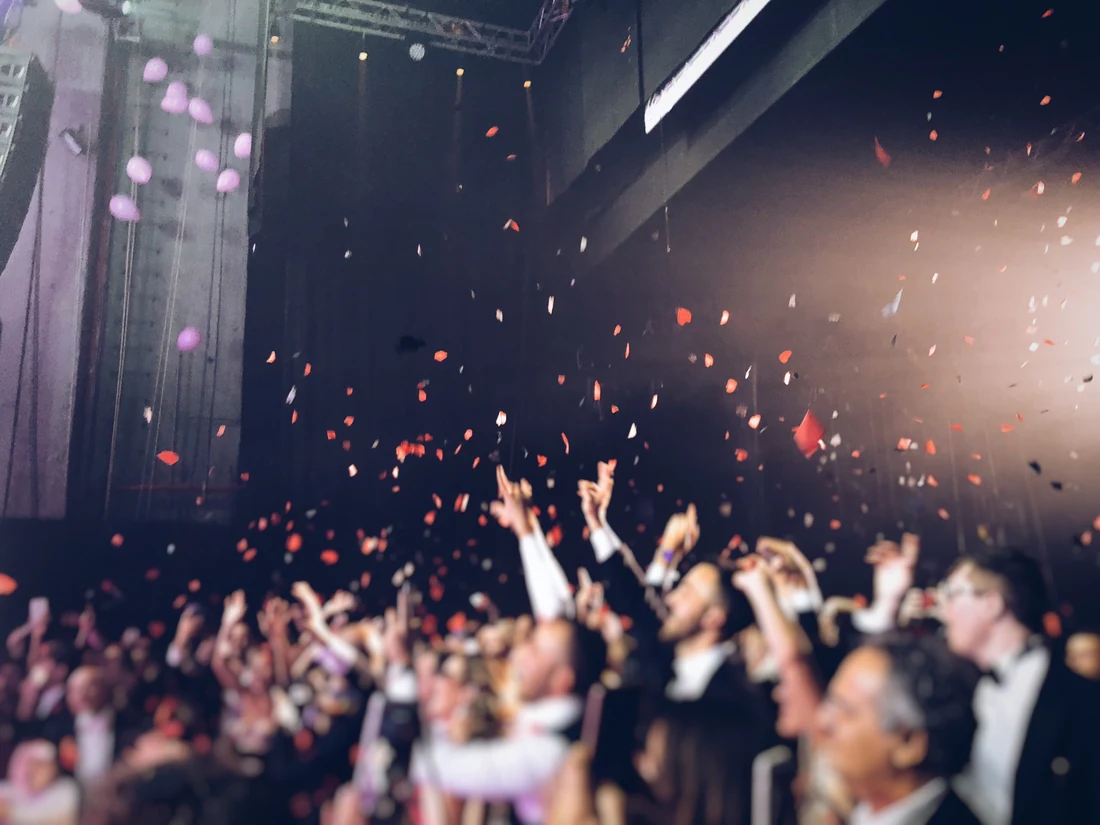A crowd celebrating beneath a shower of confetti
